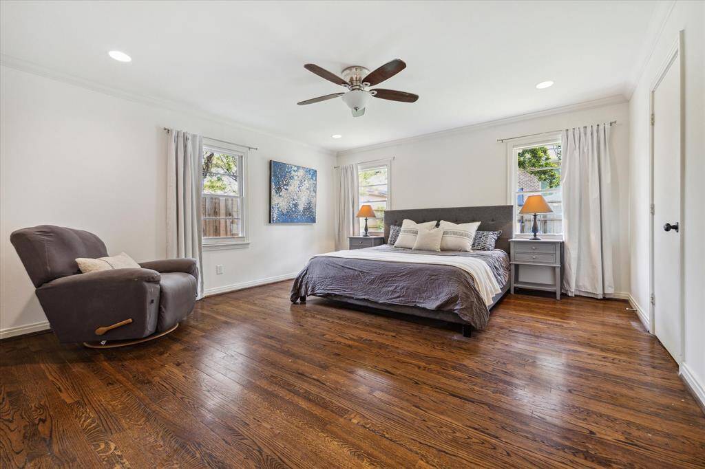 Spacious primary bedroom has beautiful hardwood flooring and has been freshly painted