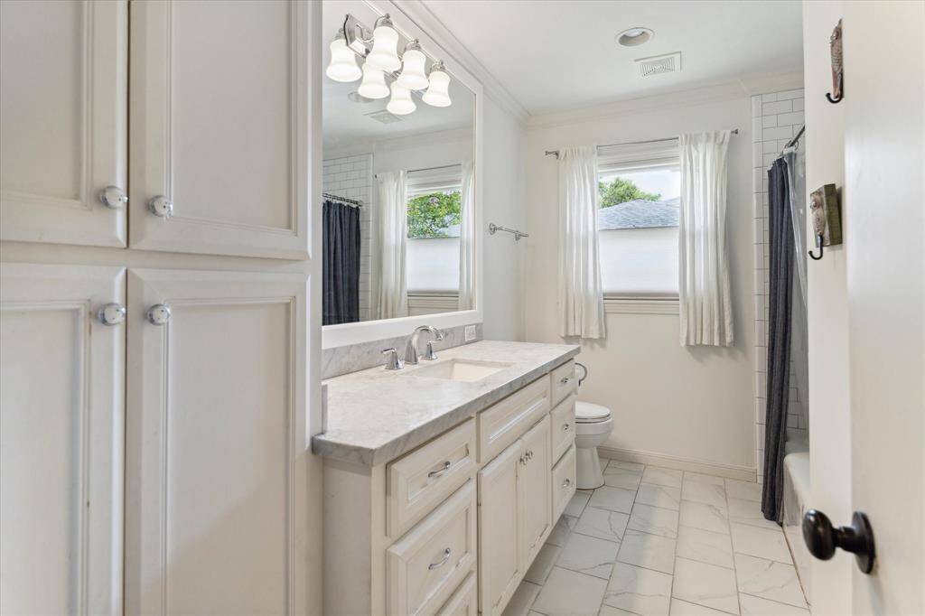 Another view of the hall bathroom shows plenty of storage and cabinets