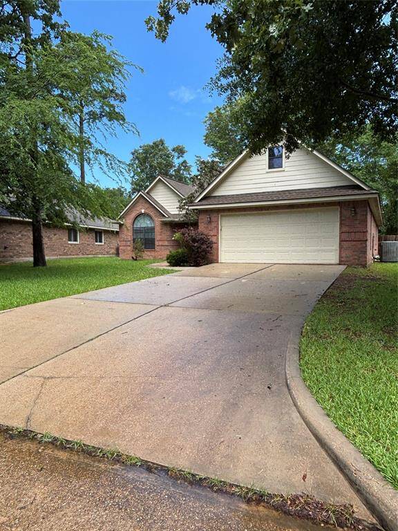 Charming single-story home with a brick facade and attached two-car garage. It features a spacious driveway, well-maintained lawn, and mature trees, offering great curb appeal in a serene neighborhood setting.