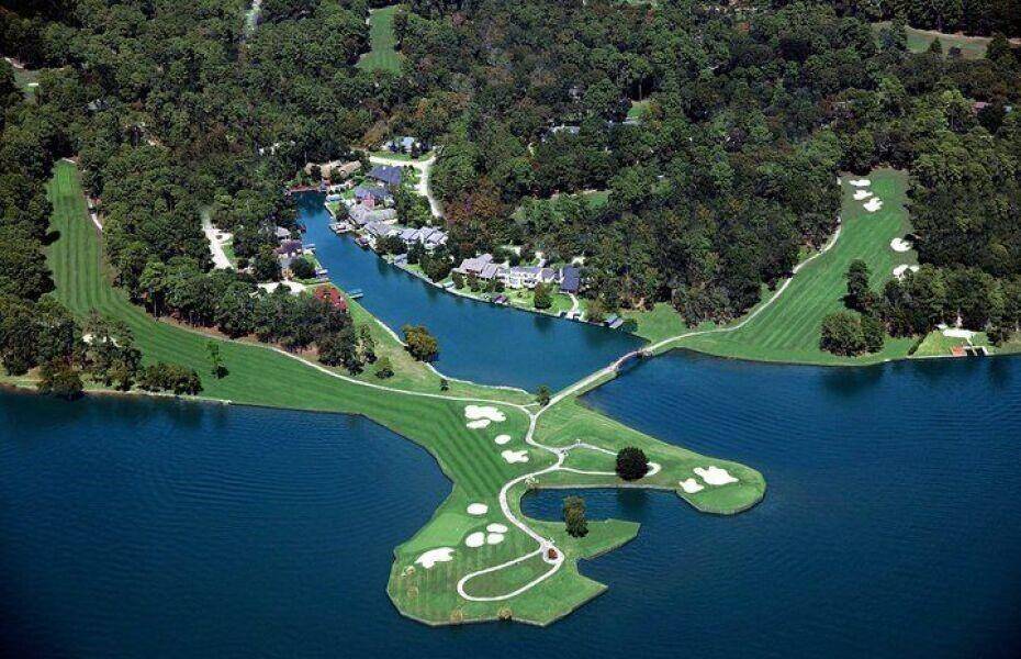 This aerial view showcases a luxurious lakeside community of Walden surrounded by lush greenery and a golf course. The homes are nestled along a scenic waterfront, providing both privacy and picturesque views. Ideal if you're seeking elegance and outdoor recreation.