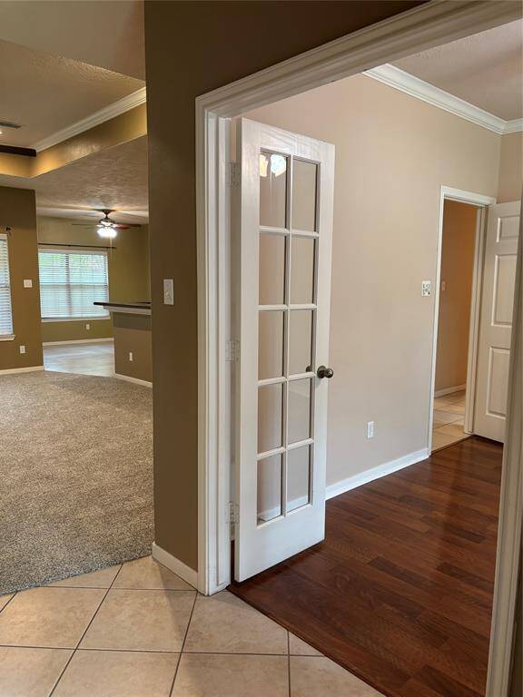 Office/extra room features a French door leading to a room with crown molding. T