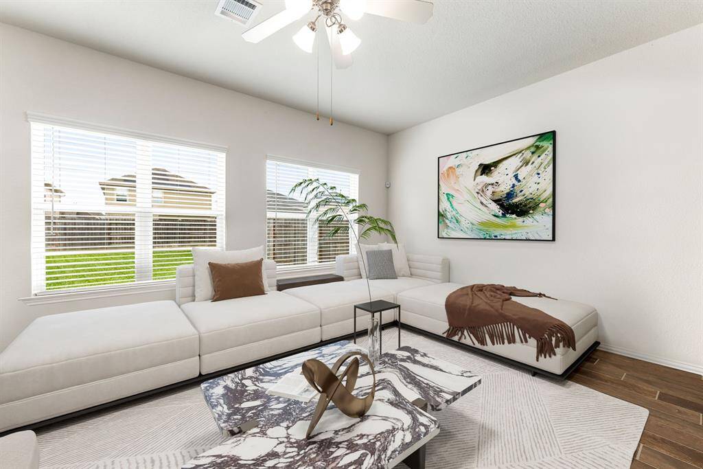 This living room is more like a GREAT room featuring a stunning fireplace with mantel detailing, custom paint, soaring high ceiling, recessed lighting, dark stained ceiling fan, and an amazing wall of windows providing a lovely view of your backyard to keep an eye out on the kids or pets playing. *Virtually Staged