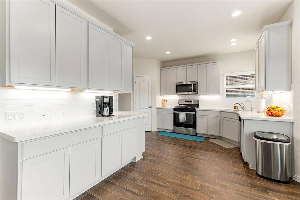 This stunning kitchen features such a beautiful light stained cabinets, custom neutral paint, quartz countertops, and light modern backsplash, and SS appliances, recessed lighting, high ceilings and walk in pantry.