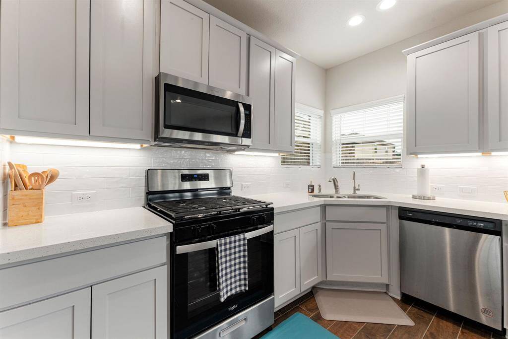 This stunning kitchen displays such a beautiful bright cabinets, custom neutral paint, granite countertops, light modern backsplash, and SS appliances, recessed lighting, high ceilings and walk in pantry.