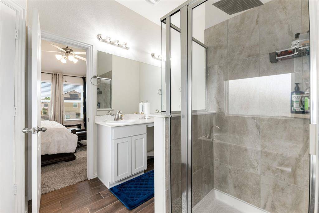 Elegant and functional, the primary bathroom features a sleek walk-in shower with floor-to-ceiling tile and modern fixtures, designed for both luxury and convenience.