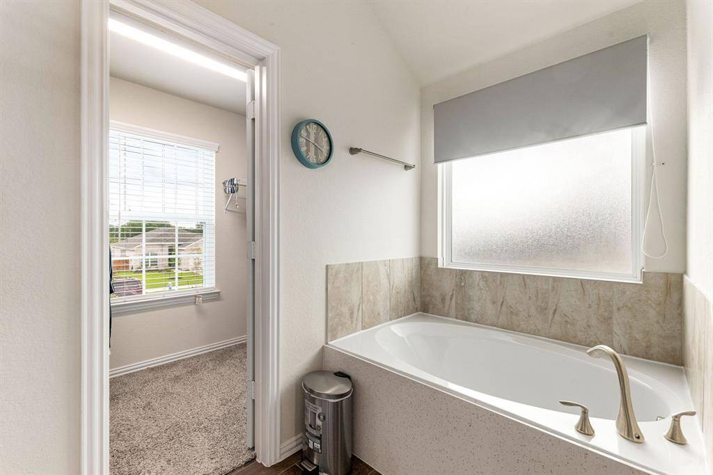This additional view of the primary bath showcases a separate garden tub perfect for soaking after a long day.