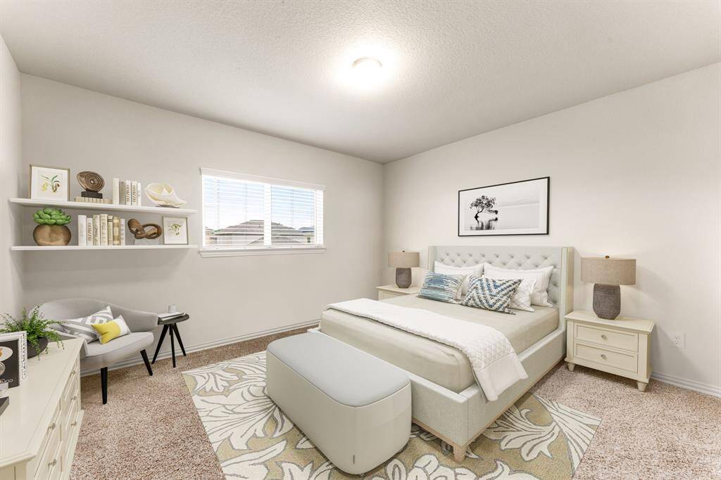 Secondary bedroom features plush carpet, custom paint, dark stained ceiling fan with lighting and a large window with privacy blinds. *Virtually Staged