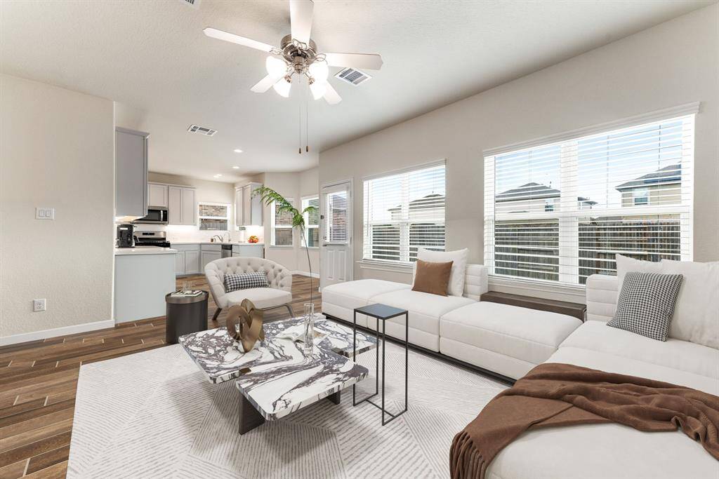 This light and bright spacious living room is the perfect layout for entertaining or just relaxing. Whether it's simply a night in or entertaining family and friends, this home has ample open space for everyone to enjoy! Featuring a ceiling fan, wood style flooring, large windows with blinds, high ceilings, and wonderful access to your gorgeous kitchen. *Virtually Staged