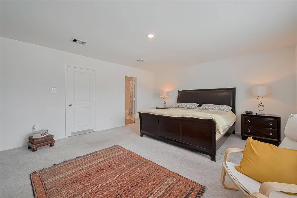 primary suite featuring two walk-in closets for ample storage and organization.