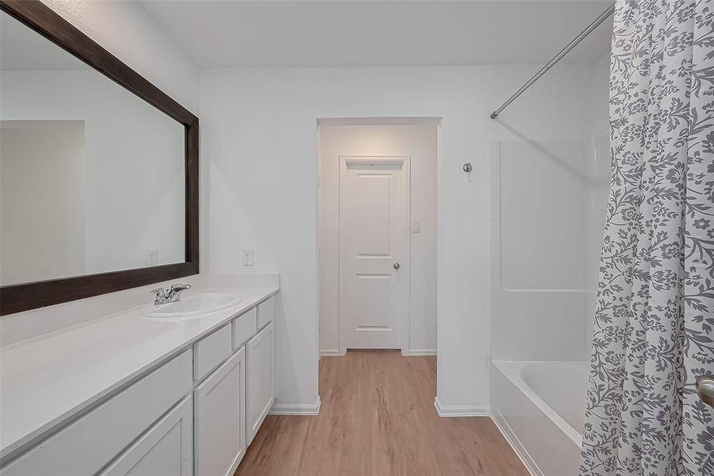 Elegant primary bathroom with a spacious layout, featuring a walk-in shower and modern finishes.