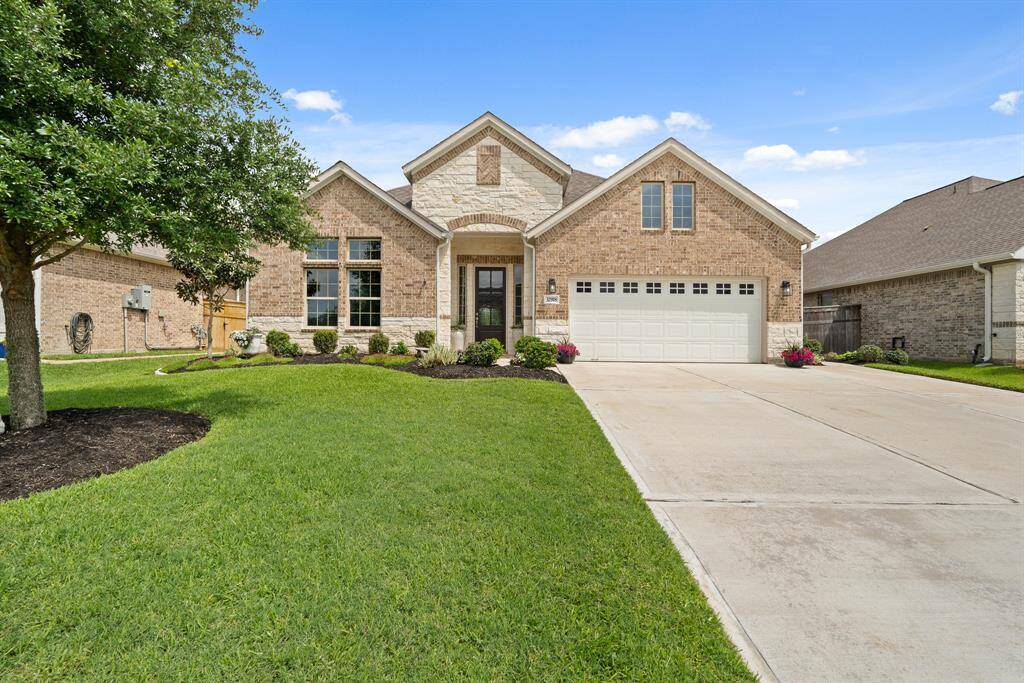 This single-story home is both warm and inviting. The perfectly married combination of brick and stone emphasizes the overhead gable and varied roof line. A pair of lights illuminate the oversized driveway that wraps around to the Backyard on the right side.