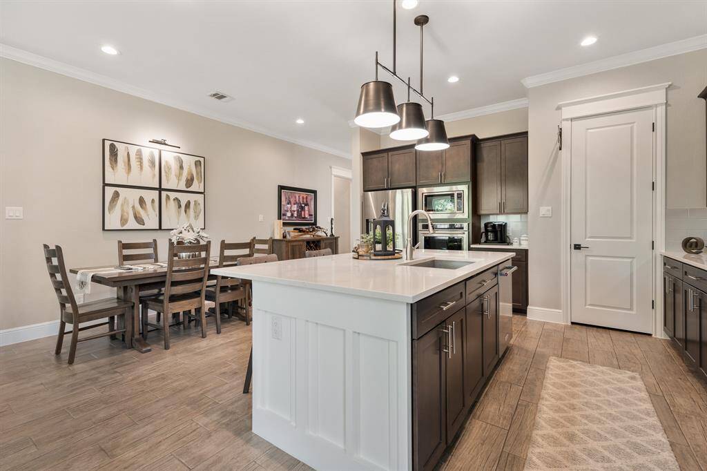The entire Kitchen is equipped with recessed lighting. However, it’s this statement, 3-light, chandelier that adds a classy, yet industrial flair to the room. Through the closed door straight ahead sits the walk-in pantry, equipped with built-in shelving and storage.