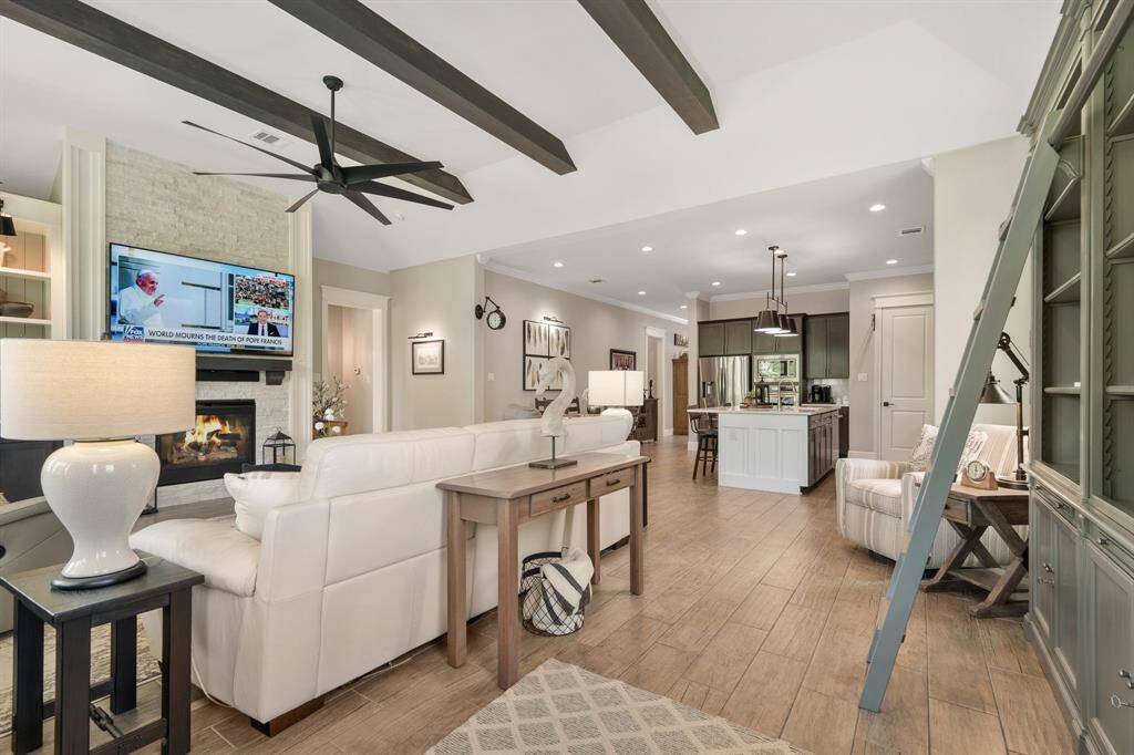 The stacked stone, gas fireplace climbs from floor to ceiling, anchoring the space and intriguing the eye.  A custom wood mantle provides a place to mount the TV, hang a piece of art, or display family photos.