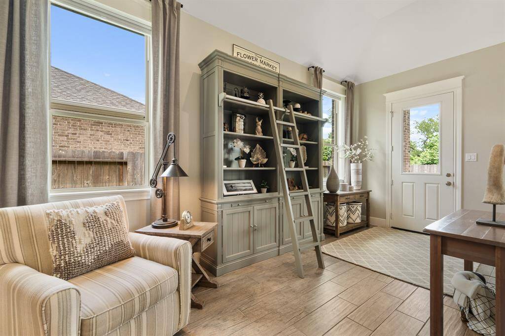 The Living Room is grand in style and size. The current homeowners have turned the back portion of the room into a comfy and cozy sitting space. The space between the two side-facing windows is perfect for a bookshelf, artsy floating shelves or this space could even be used as an additional dining area. The glass-plated door ahead allows direct access to the Backyard.