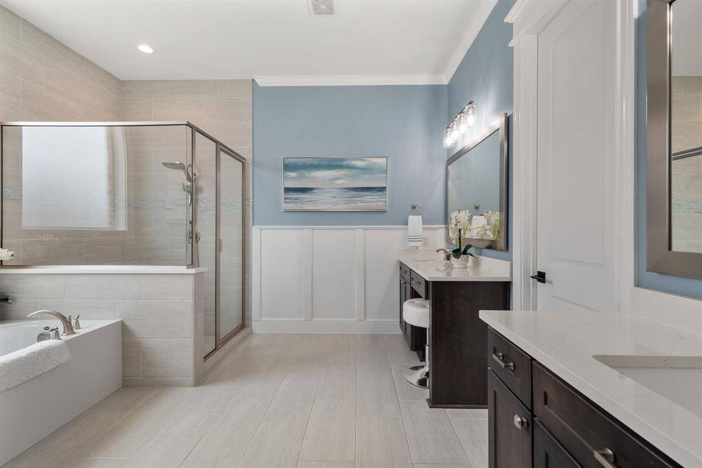 Peace and tranquility are found in this Primary Spa. The water blue hue, sandy colored, wood-like tiles, and crisp white wainscotting paint a beachy portrait that encourages the body to finally exhale. Ahhhh…