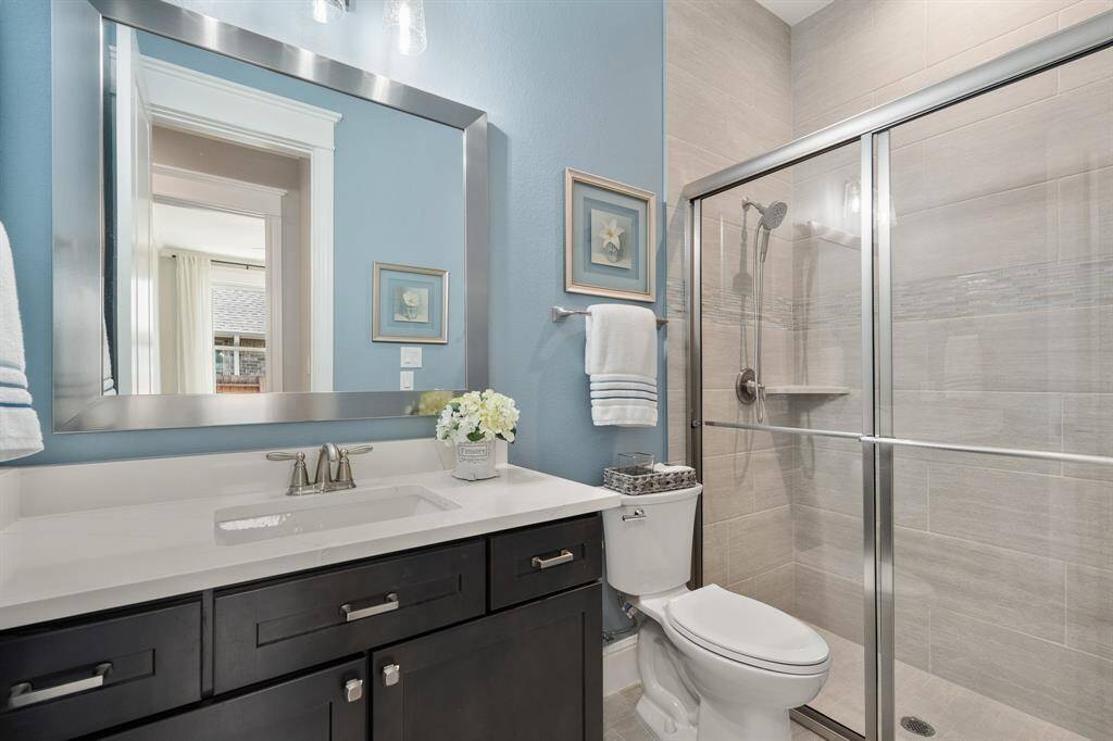 Two Secondary Bedrooms share this centrally located Full Bath. Adorned with a walk-in shower, undermount sink, quartz countertop, framed mirror, and storage below, this space is sure to suit the needs of everyone. A linen closet is located just outside of the Bathroom, providing an ideal spot to store additional towels and linens.