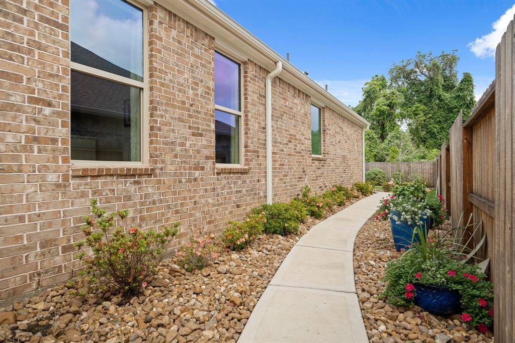 The Patio extends to a shrub-lined walkway that wraps around the side of the home, leading directly to the extended driveway. This is proof that a Side Yard can be functional as well as a thing of beauty!