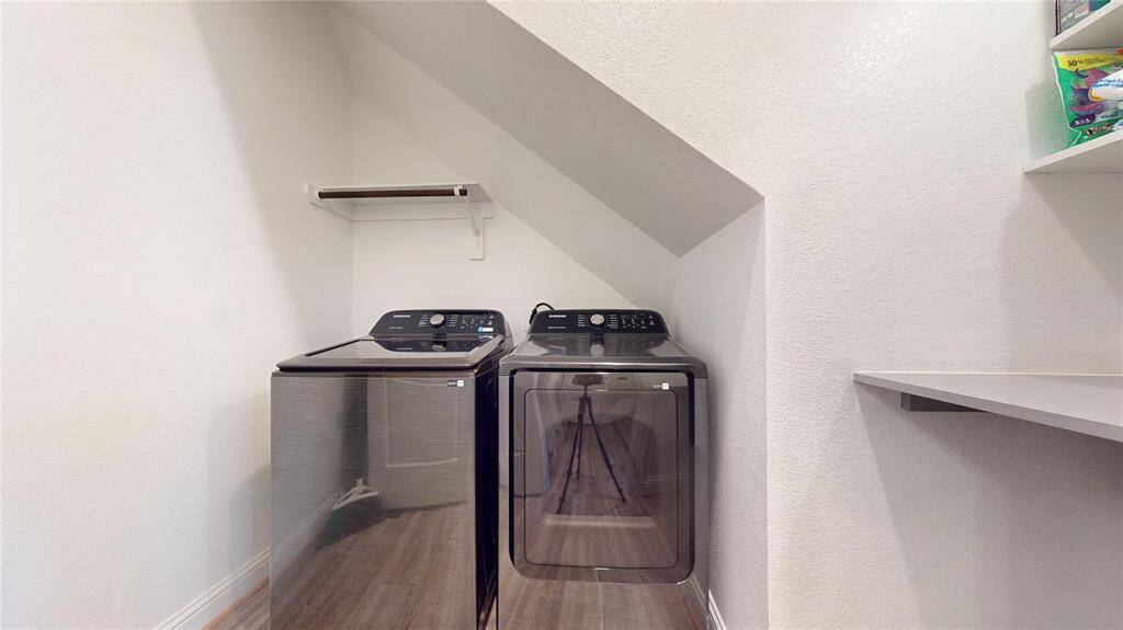Conveniently located under the stairs, this cleverly designed laundry nook maximizes space with modern appliances and additional shelving.