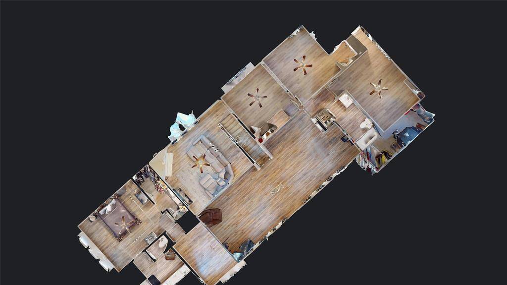 This is a 3D floor plan of a home featuring an open layout with visible living, dining, and bedroom areas. The space showcases wood flooring and ceiling fans, offering a clear overview of the home's layout and flow.