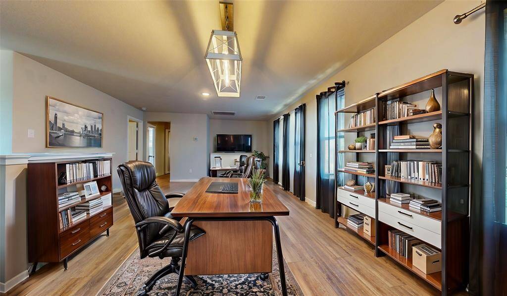 Spacious and stylishly staged loft featuring elegant shelving, ample natural light, and a modern workspace. Perfect for a home office or creative studio.