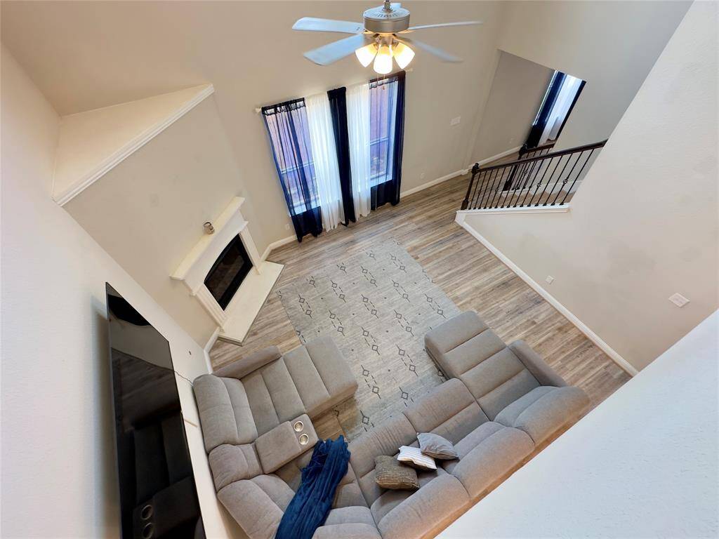 Stunning loft view overlooking the spacious living area, complete with elegant flooring and a cozy fireplace.