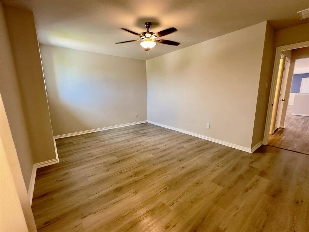 Spacious upstairs guest bedroom with modern flooring.