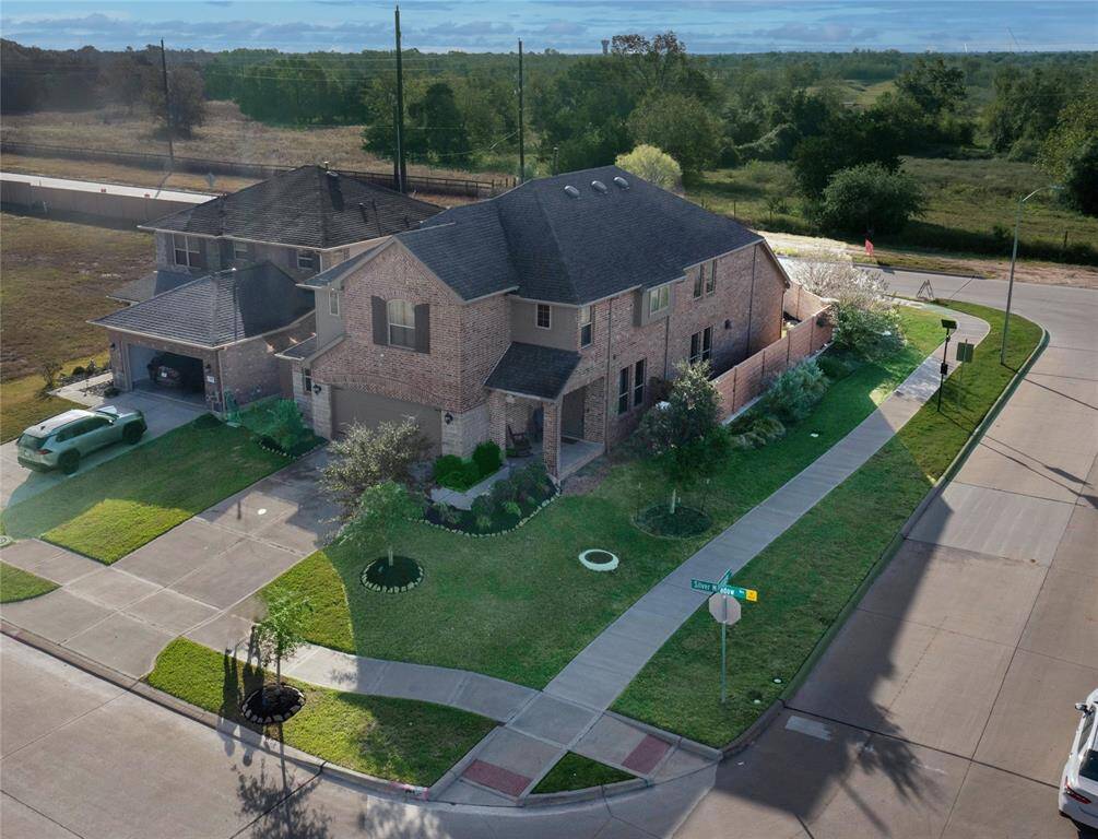 Prime corner lot with stunning aerial view, showcasing spacious layout and lush landscaping. Ideal for privacy and curb appeal.