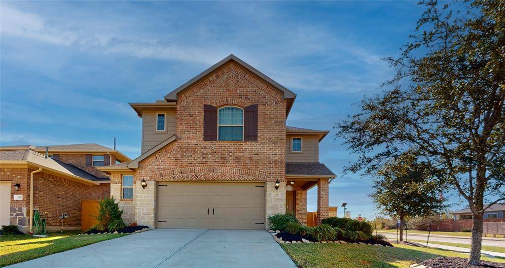 Charming two-story brick home with a spacious driveway, inviting porch, and well-manicured landscaping—perfect for family living.