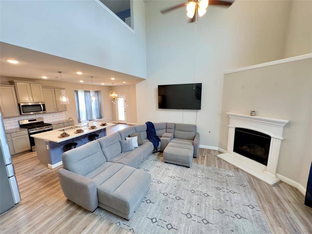 Spacious family room featuring soaring ceilings and a cozy gas fireplace.