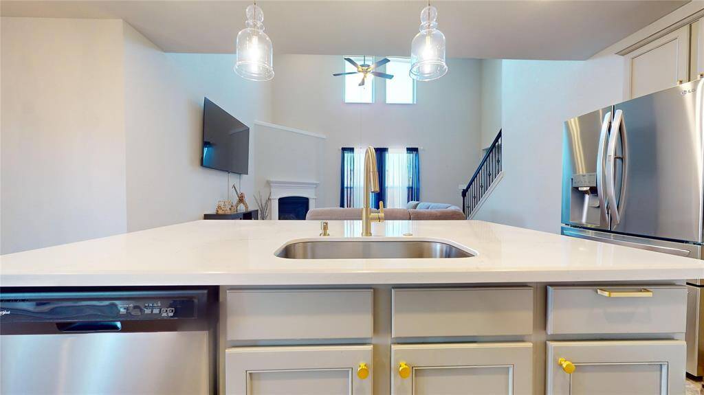 This modern kitchen island features a sleek design with a built-in sink, ample countertop space, and stylish lighting, perfect for cooking and entertaining.