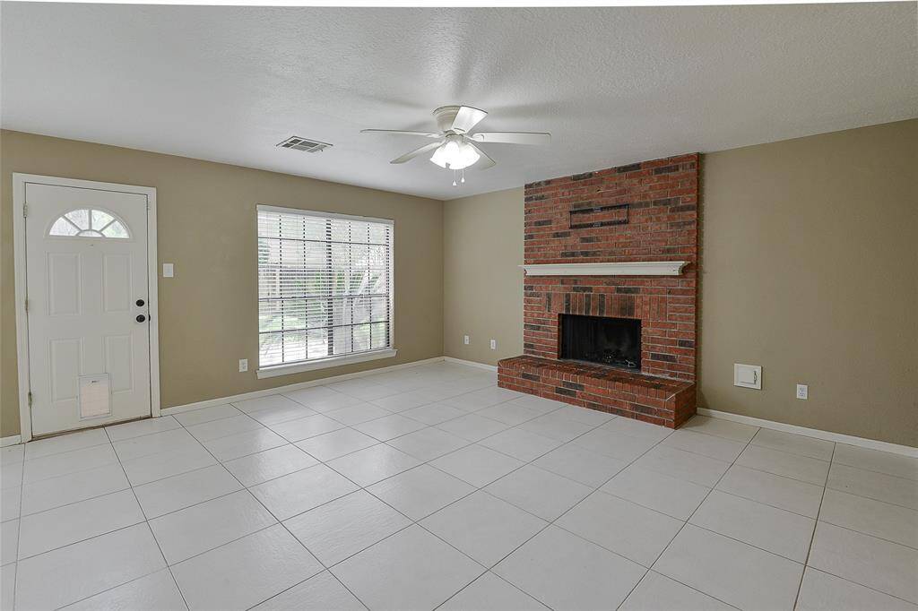 Family room features a brick fireplace and overlooks the backyard.