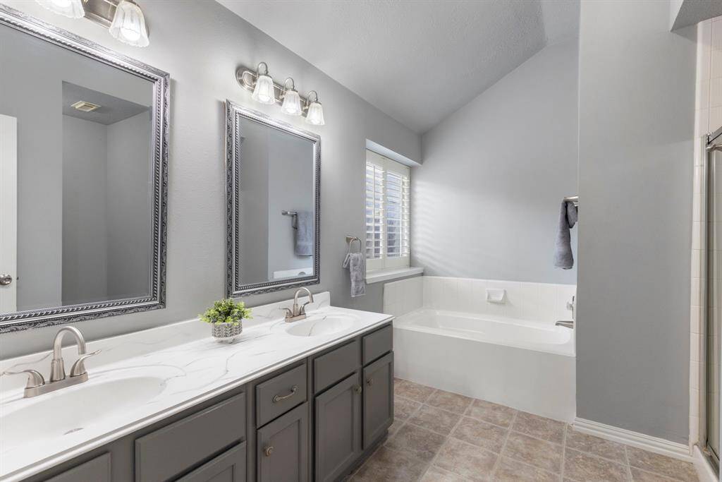 The primary bathroom offers double sinks, stunning dual mirrors, and an immense amount of space!