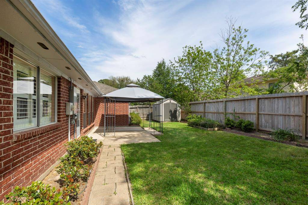 The paved walkway gives that perfect touch to the cozy backyard.