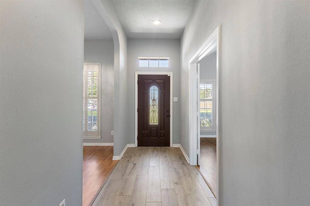 The welcoming entryway features a rich wood door with decorative glass.