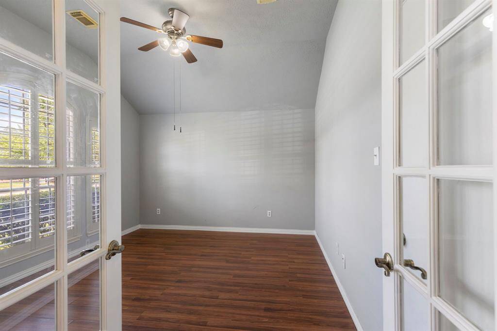 Step inside the spacious and bright study featuring large windows with plantation shutters.