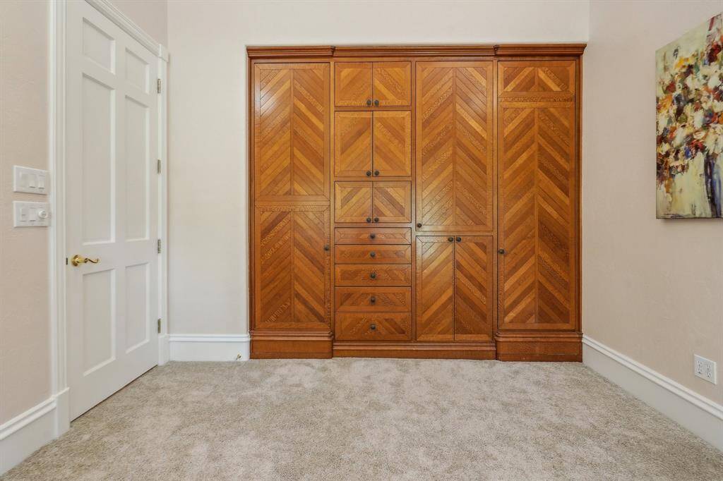 Secondary bedroom with built in wall cabinetry featuring lovely wood inlay.