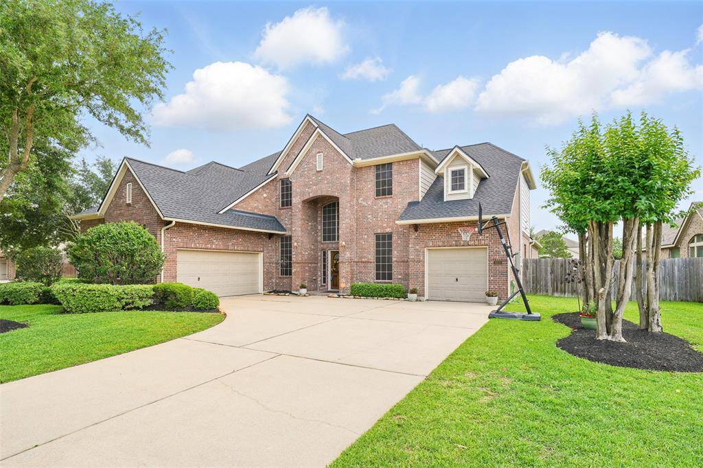 Front door, driveway, and 3 attached garages
