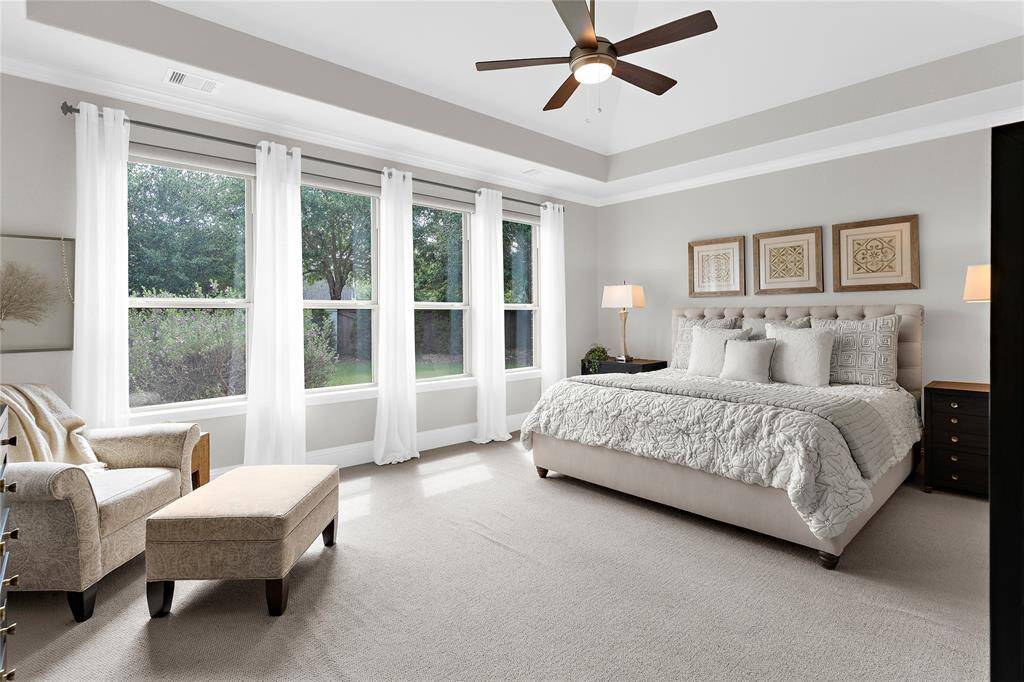 This large primary bedroom has lots of natural light. All these windows have electronic shades controlled by a remote control.