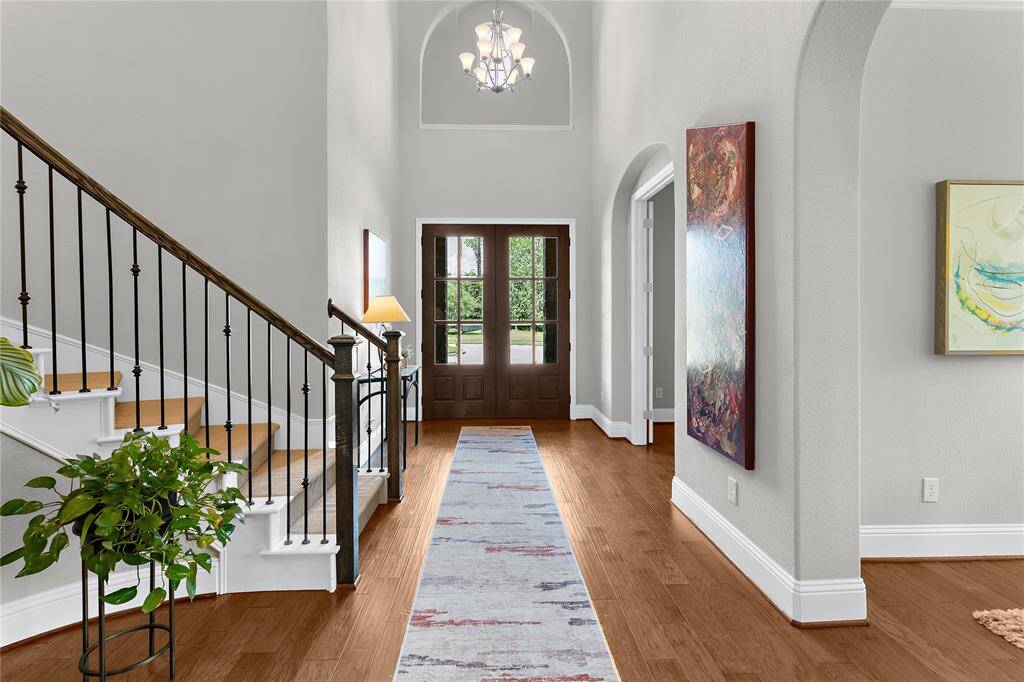 Another view of foyer showing its double wood door entry and the stunning flooring.