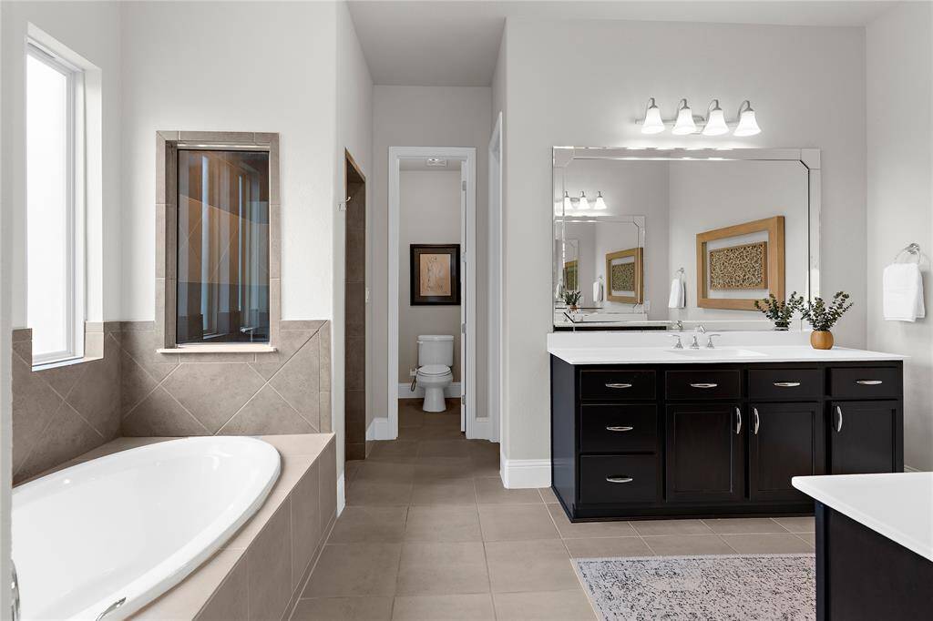 This spacious master en-suite has a stand alone private shower next to its large soaking tub.