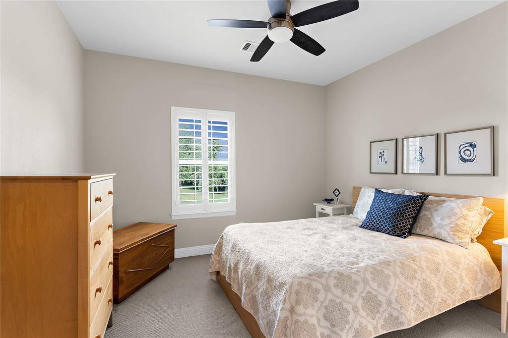 Bedroom 4 with plantation shutters, neutral wall colors and ceiling fan.