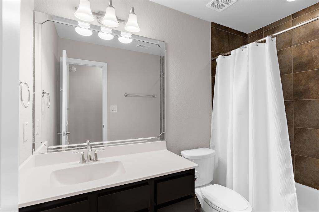 Bedroom 4 full bathroom with tile in shower extended to the ceiling.