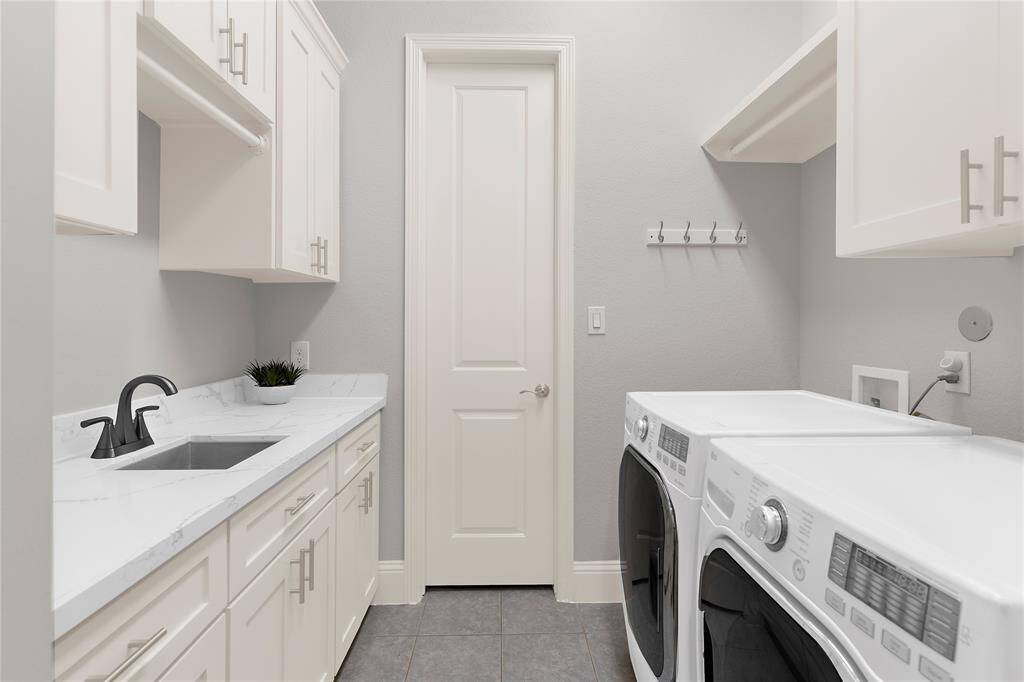 This stylish updated laundry room is light and airy with loads of storage and a sink for your convenience.
