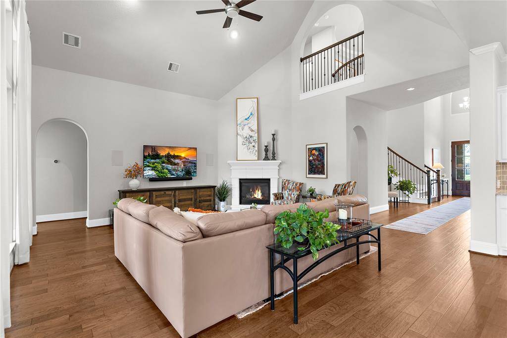 This spacious living room has neutral colored walls and accented with a classic cozy fireplace.