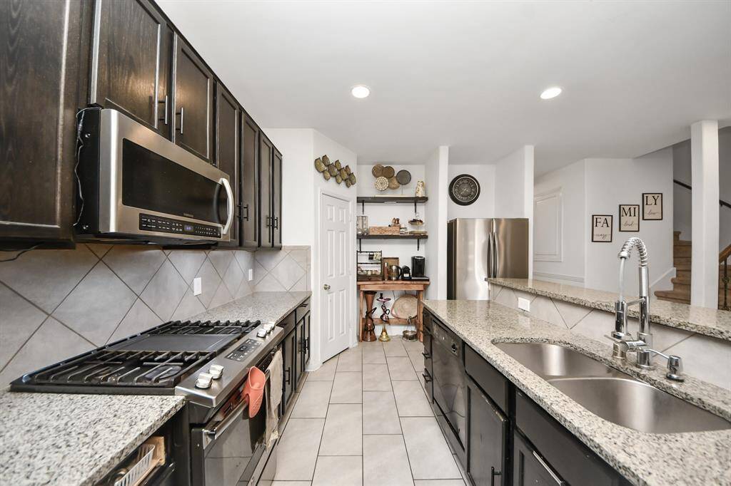 The kitchen boasts ample cabinet space, sleek stainless steel appliances, and a functional design for effortless cooking.