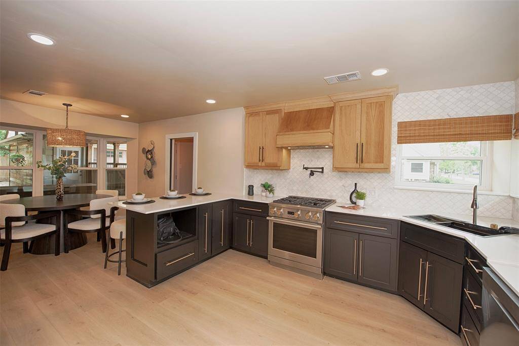 Entry to the gourmet kitchen updated with luxury vinyl floors, white quartz counters and stainless appliances.