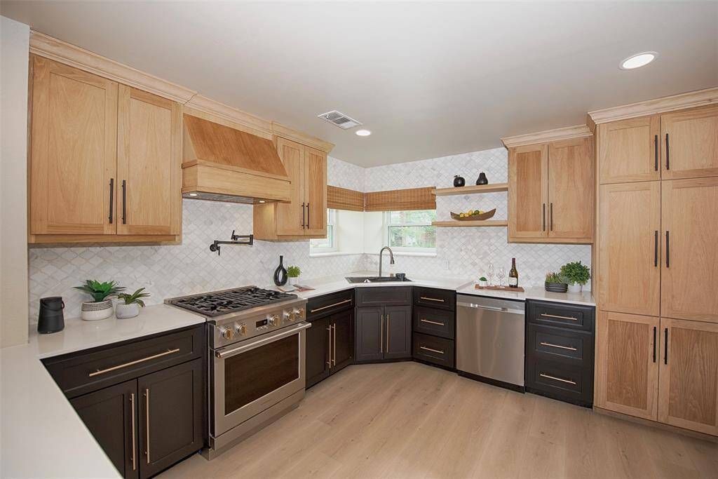 Kitchen provides custom shaker style cabinetry with different wood colors for upper and lower storage. Provides great contrast.