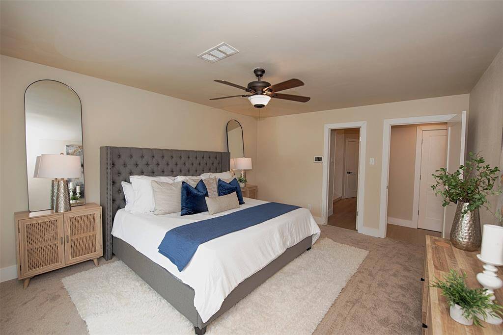 A view of the primary bedroom with access to the custom en suite bathroom.