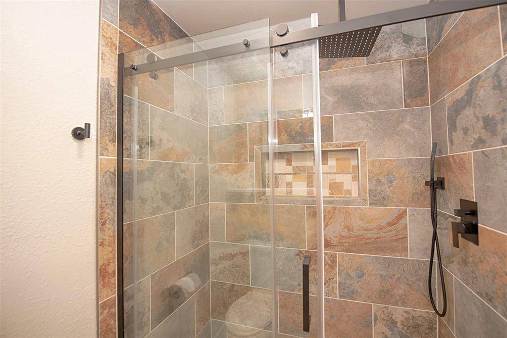 Great walk in shower with rainwater shower head, gorgeous tile work and great niche for keeping your shampoo and bathing essentials.