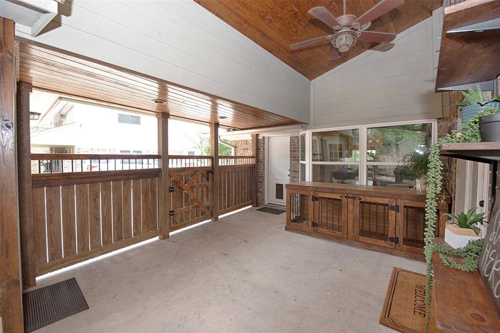 A view of the patio showing the door to the utility room, updated gate and there is an extra large dog crate which may be available for purchase. Will easily fit two large dogs or several small ones.